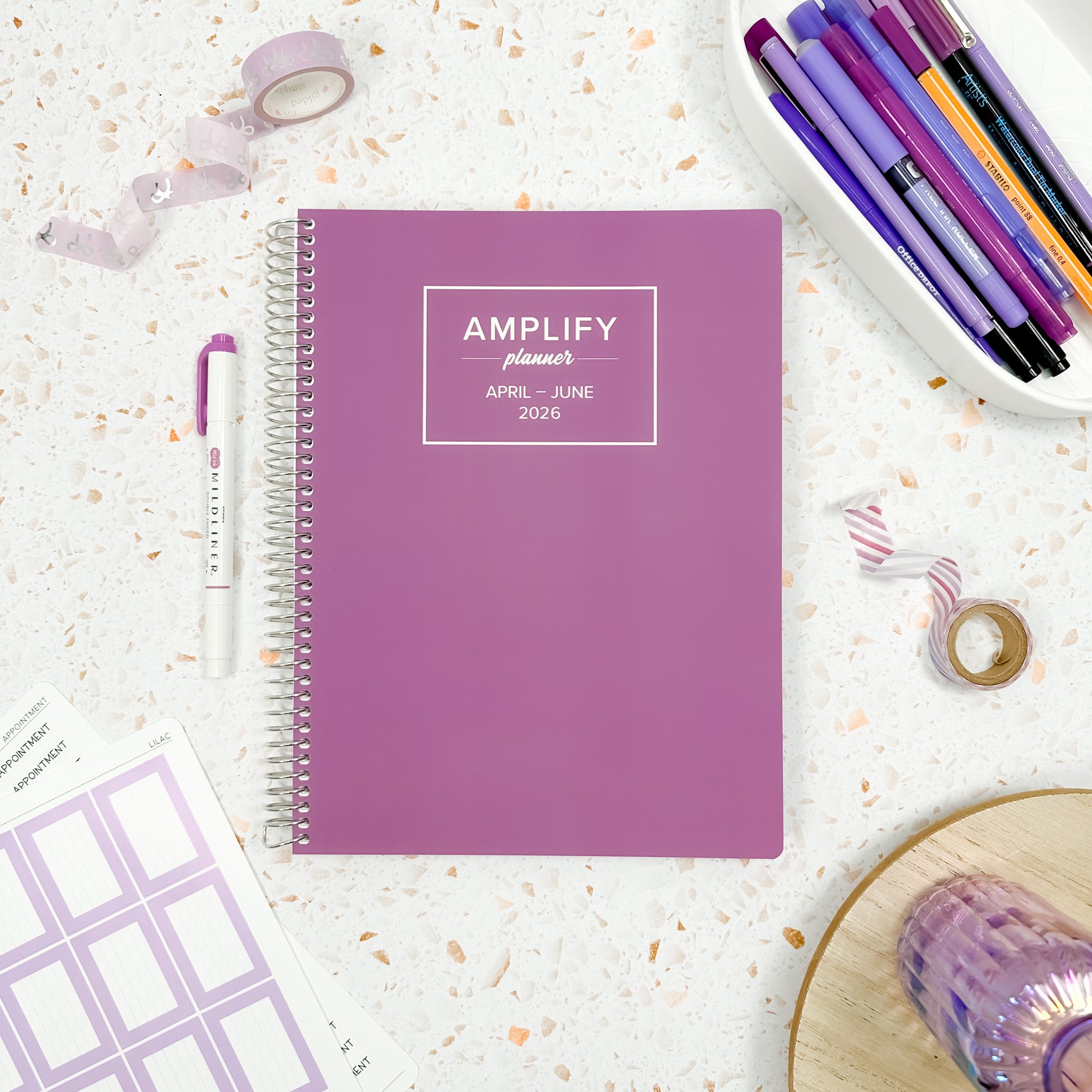 Daily Planner - April-June 2026 - Garden Lilac displayed with stationery items on a textured background.