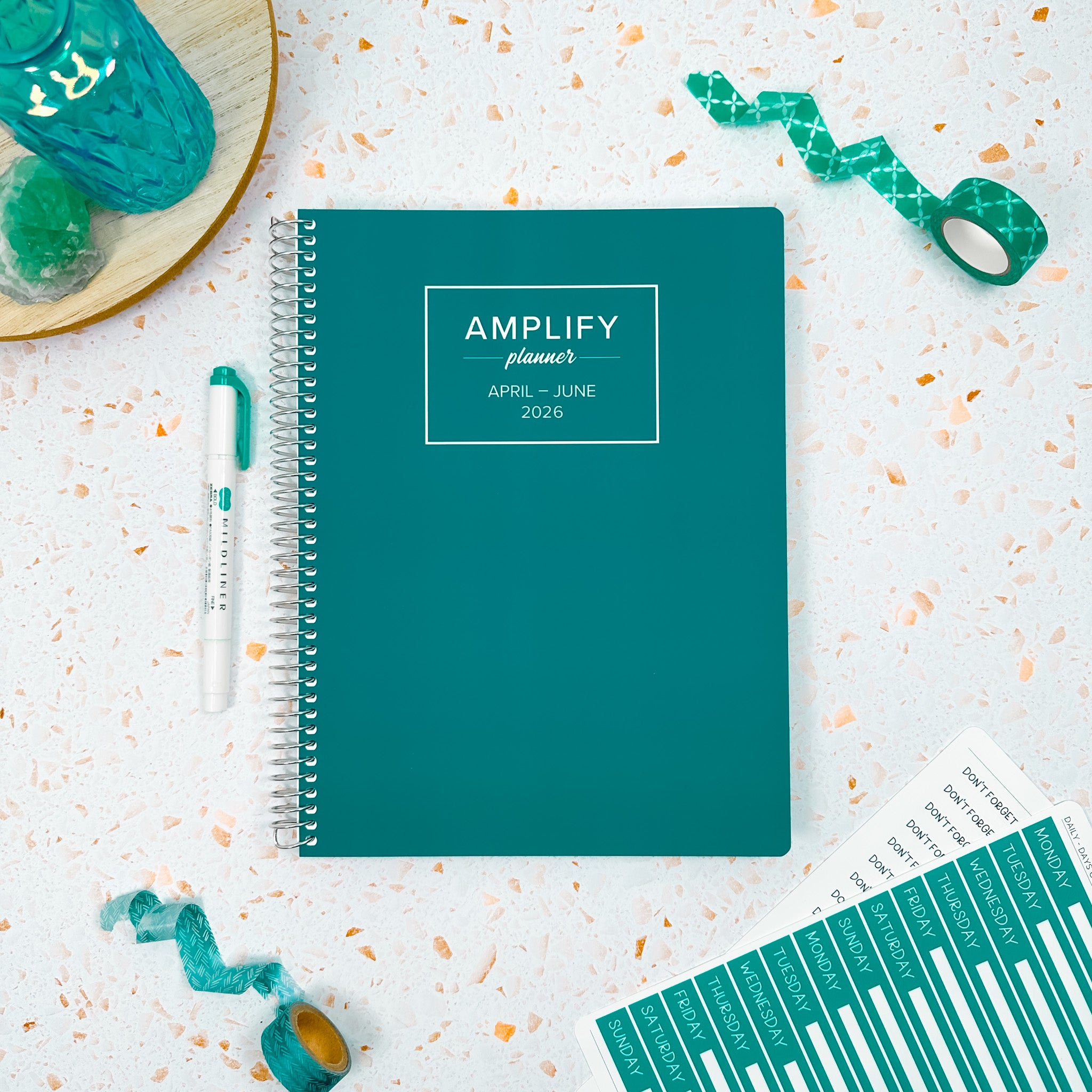 Daily Planner - April-June 2026 - Quiet Teal displayed with stationery items on a textured background.