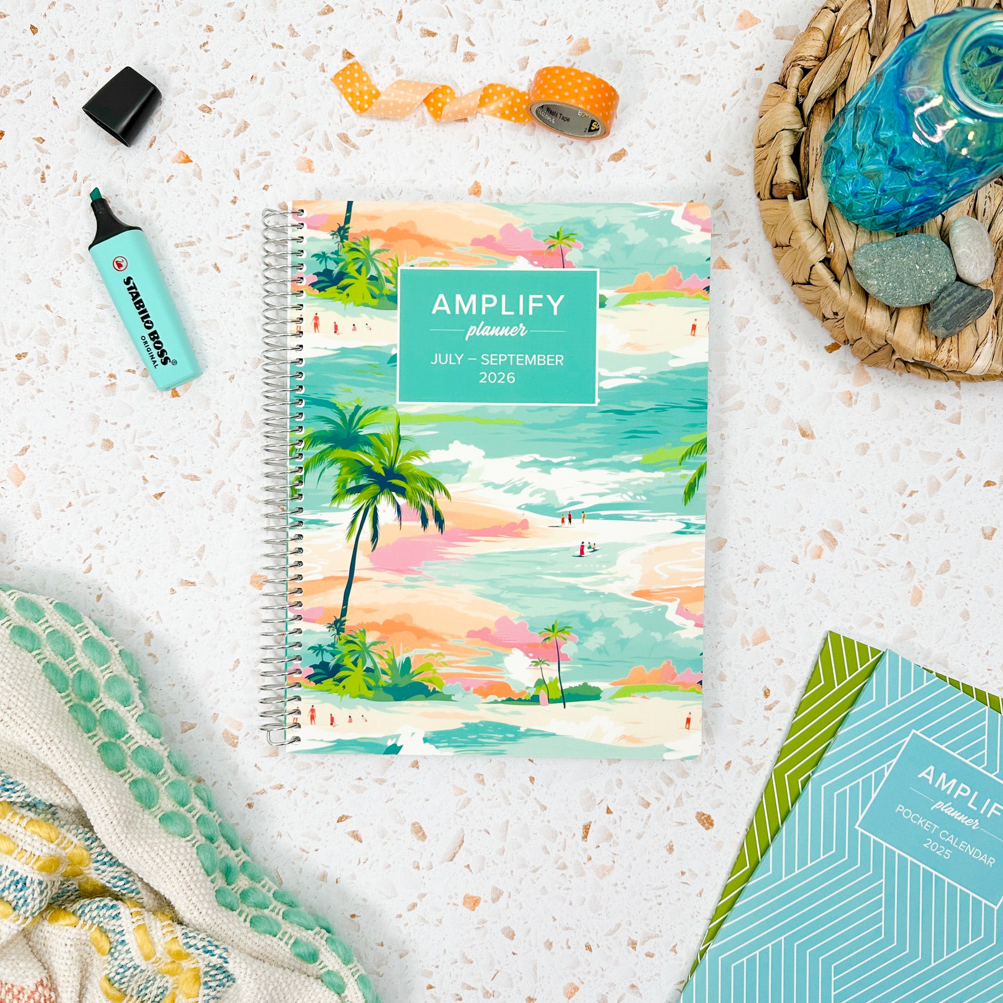 The Daily Planner - July-September 2026 - Island Afternoons set on a stylish desk, surrounded by creative supplies. Ideal for organizing your days in a vibrant and artistic manner.