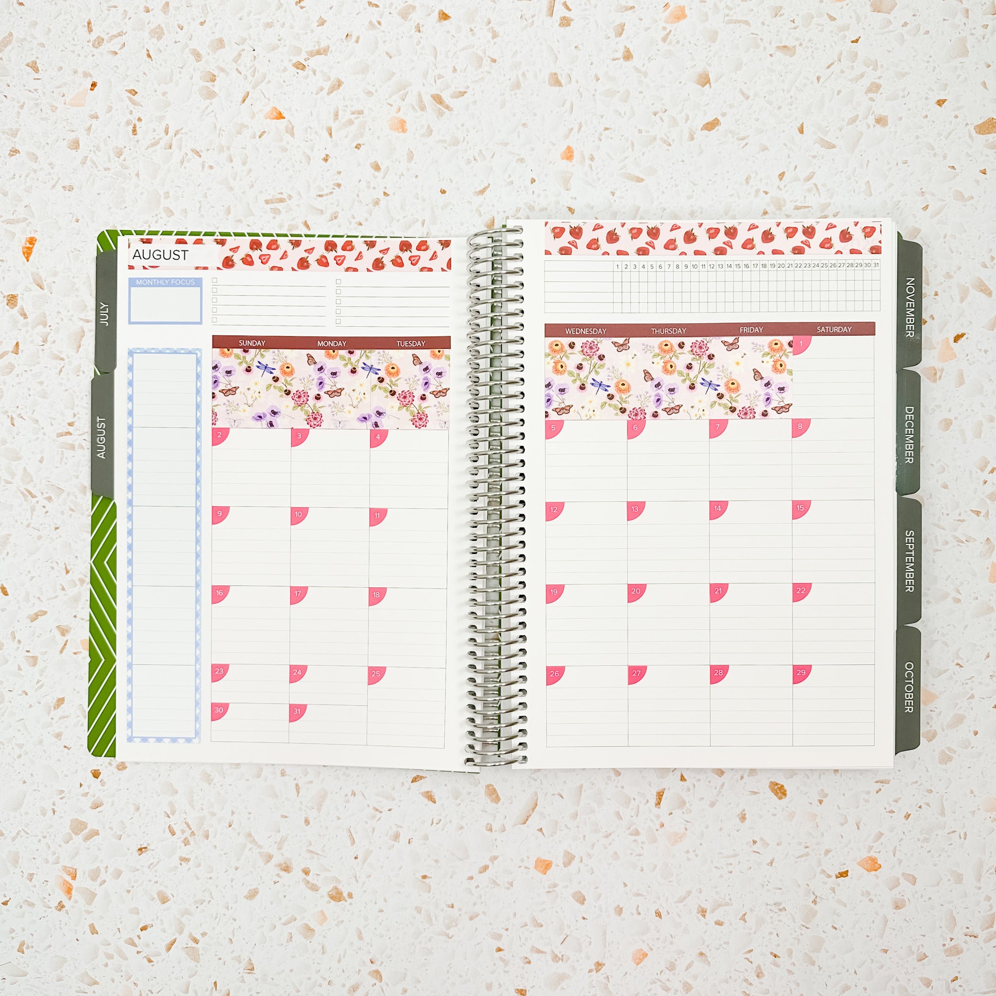 Open monthly planner spread decorated with the Summer Picnic Monthly Sticker Kit featuring strawberry accents, soft floral patterns, pastel blue details, and pink date covers for a bright and playful summer-inspired layout.