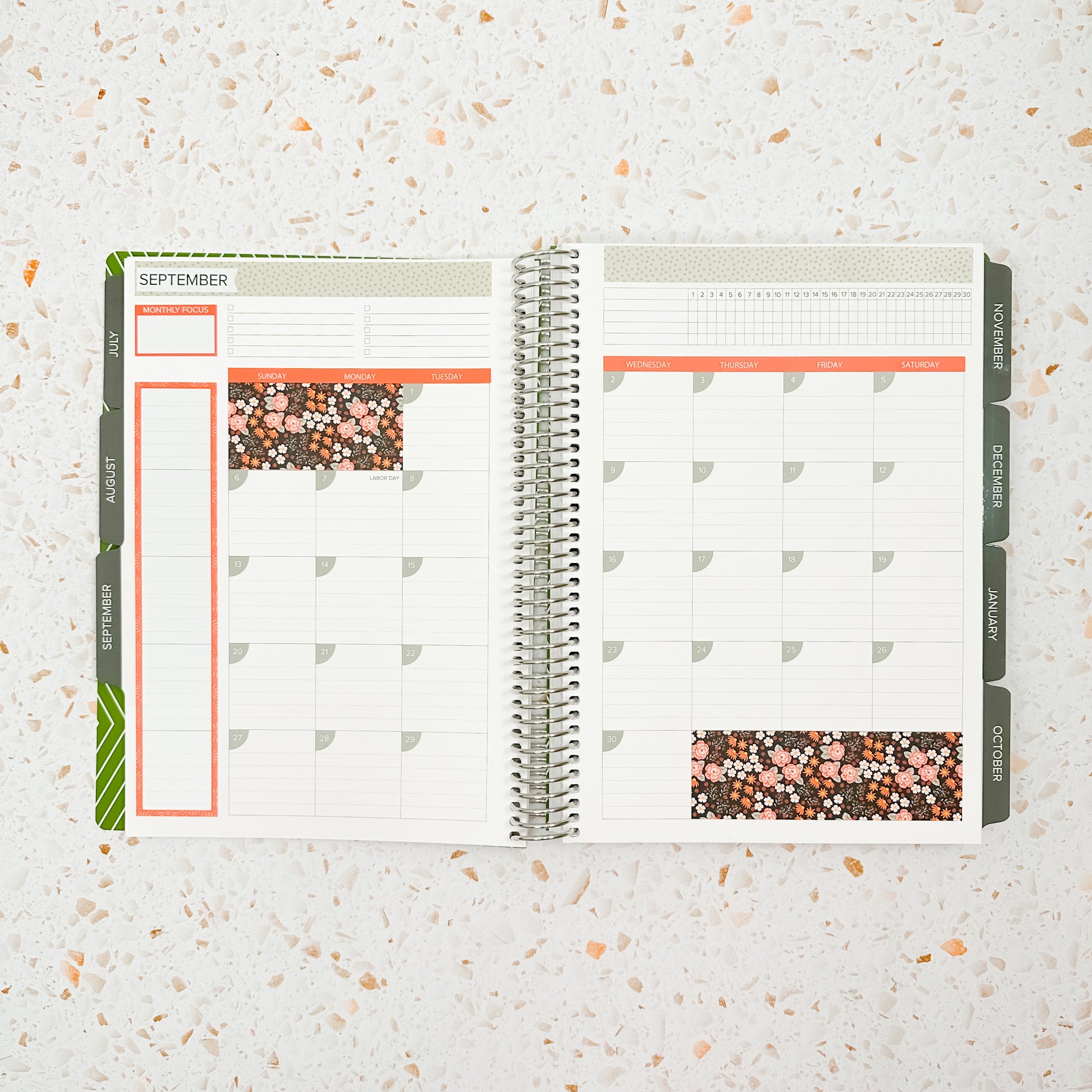 Open monthly planner spread decorated with the Cozy Fall Monthly Sticker Kit featuring warm floral accents, muted sage green details, and soft orange headers for a cozy autumn-inspired planner layout.