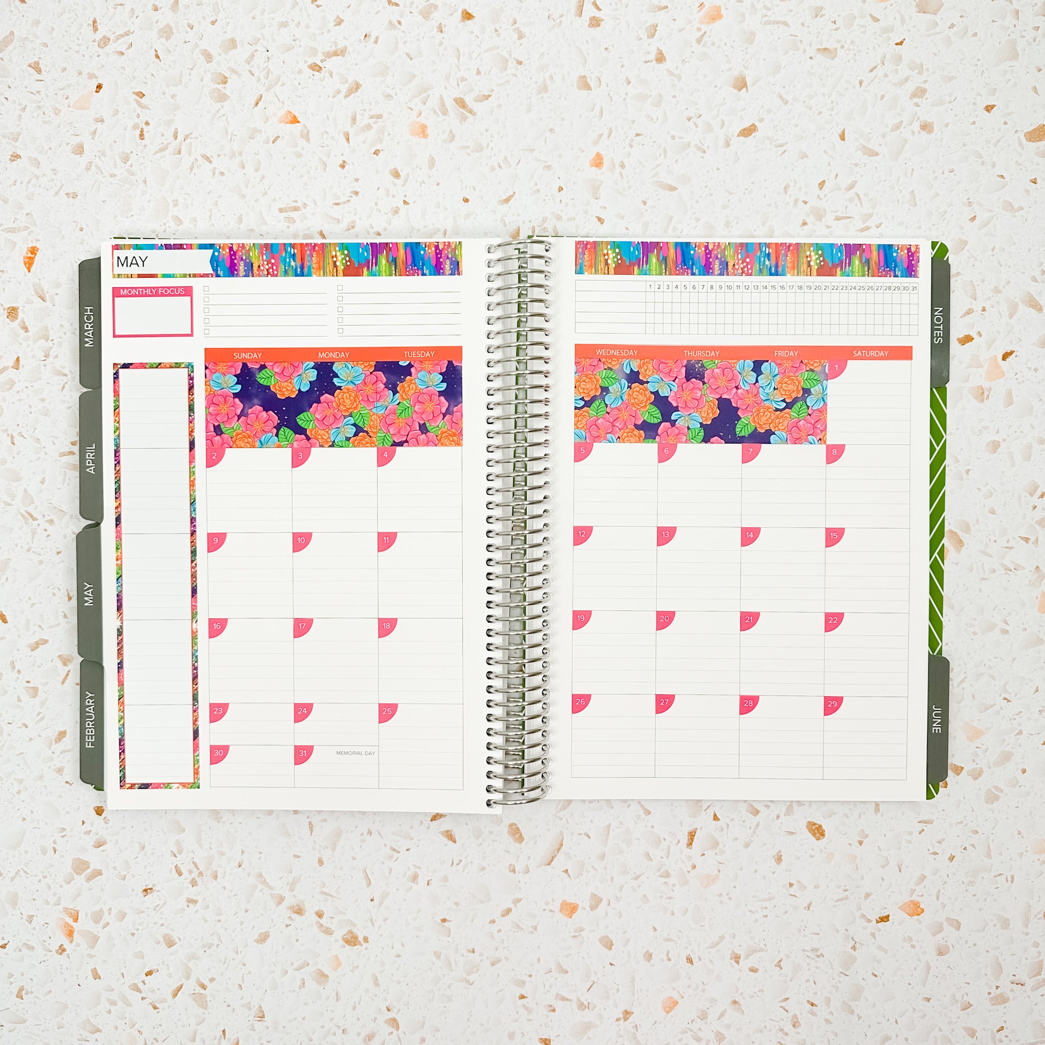 Open monthly planner spread decorated with the Floral Fiesta Monthly Sticker Kit featuring bright floral stickers, colorful borders, and vibrant pink, orange, teal, and purple accents.