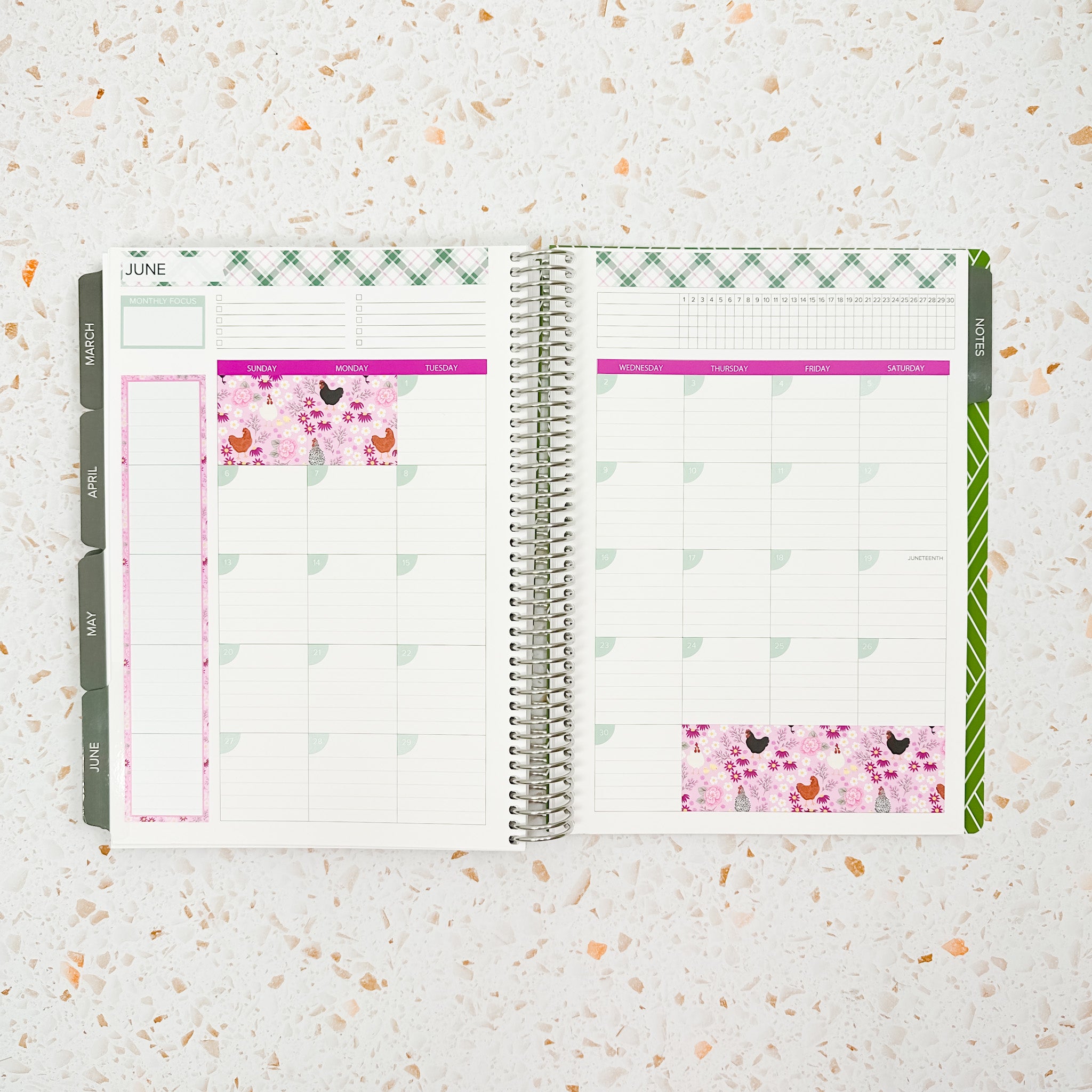 Open monthly planner spread decorated with the Farmhouse Monthly Sticker Kit featuring pink floral and chicken-patterned stickers, soft sage green plaid accents, and bright magenta headers for a cozy cottage-inspired planner layout.