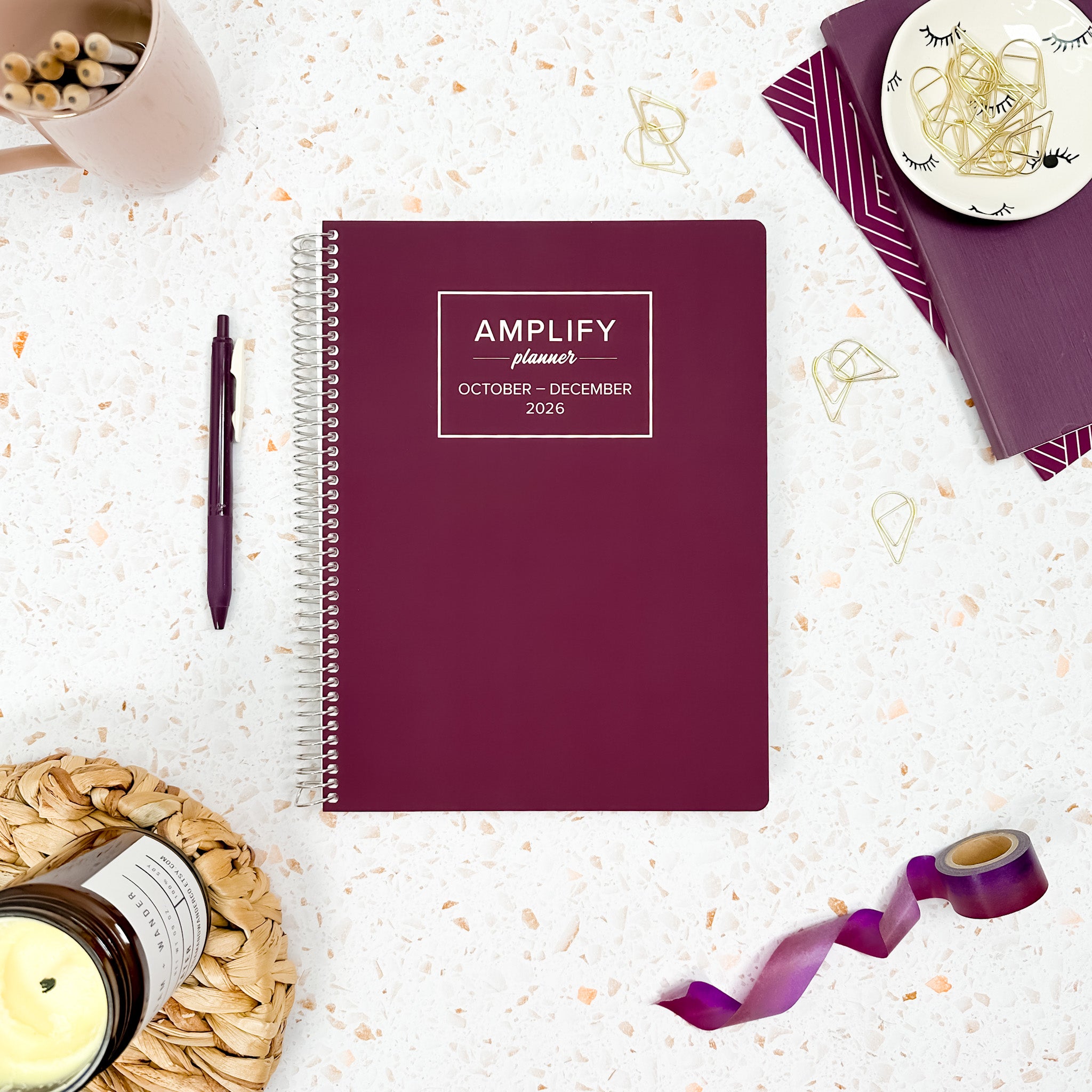 Daily Planner - October-December 2026 - Amplify Planner displayed on a desk with creative tools, showcasing its stylish tan cover.