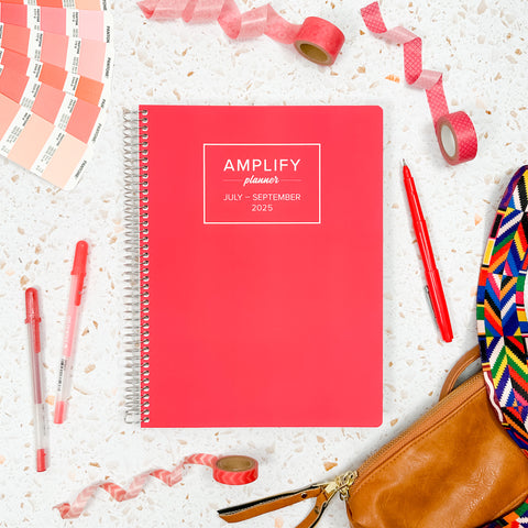 coral crush 2025 daily amplify planner on styled background