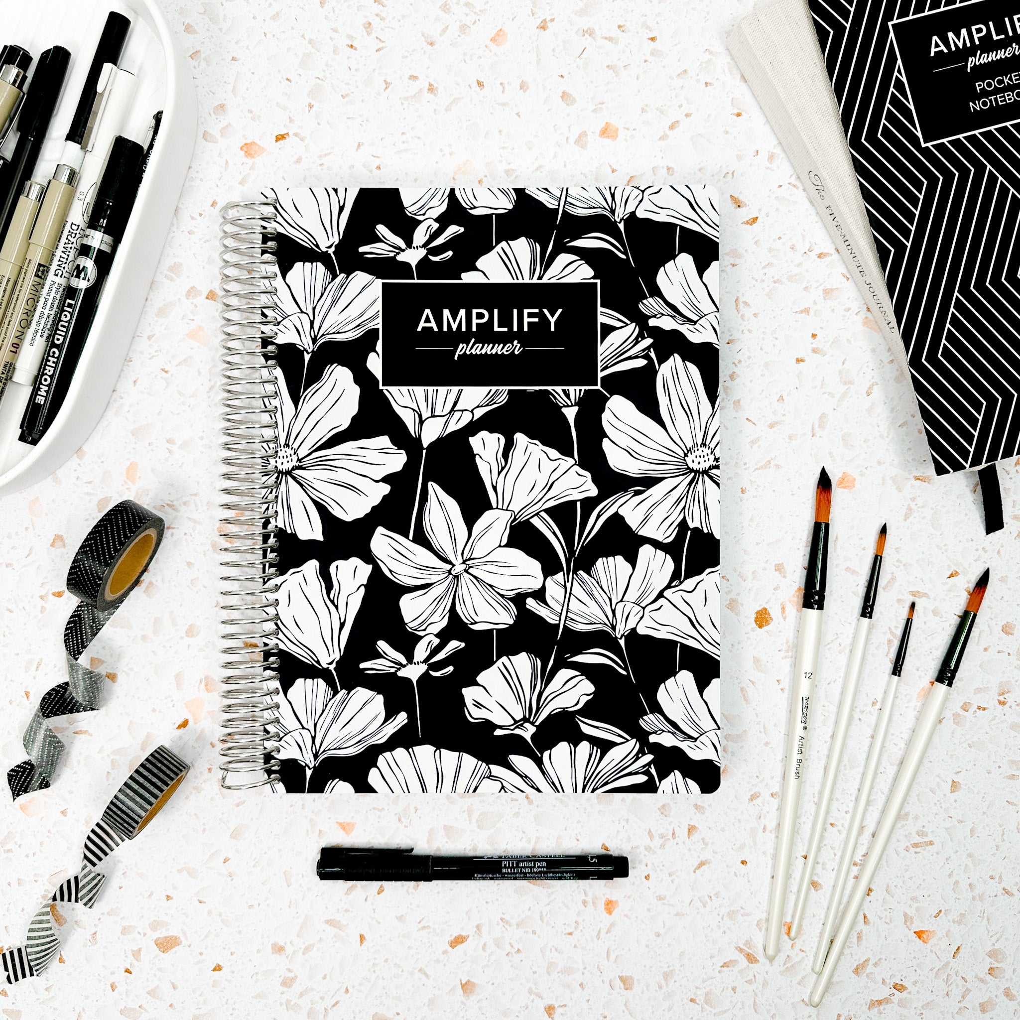 Still in Bloom weekly amplify planner on styled background