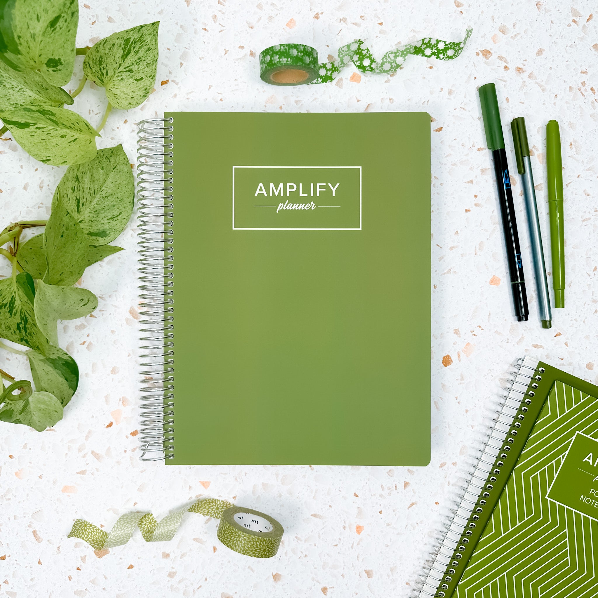 Weekly Planner - July 2026-June 2027 shown alongside green stationery items on a table with a Fresh Start Green cover.
