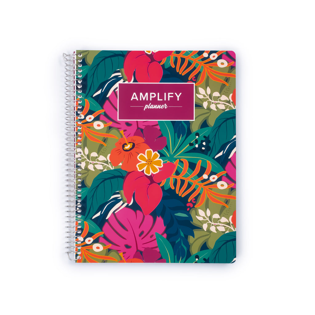 A spiral-bound planner titled 'AMPLIFY planner' with a colorful tropical floral pattern, shown on a plain white background.